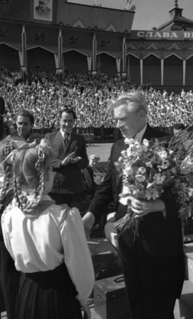 Bērnu koru dalībnieki sniedz ziedus X Vispārējo latviešu Dziesmu svētku diriģentam Jēkabam Mediņam