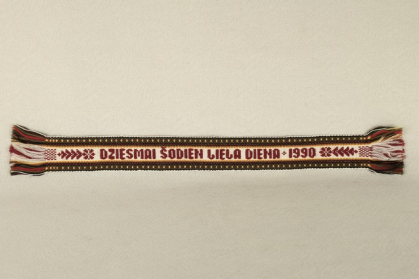 Grāmatzīme, austa; ar uzrakstu "Dziesmai šodien liela diena. 1990"