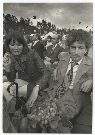 Grupas foto. Ausma Kantāne un Imants Ziedonis XVI Vispārējo latviešu Dziesmu svētku skatītāju rindās