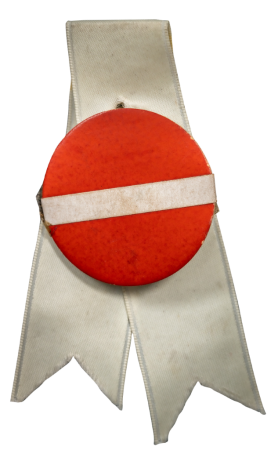 Paštaisīta nozīmīte, taisīta latviešiem, kurus Zigrīda Daškevica pavadīja vilcienā uz Dziesmu svētkiem Hamburgā 1964. gadā, iesprausta baltā atlasa lentītē